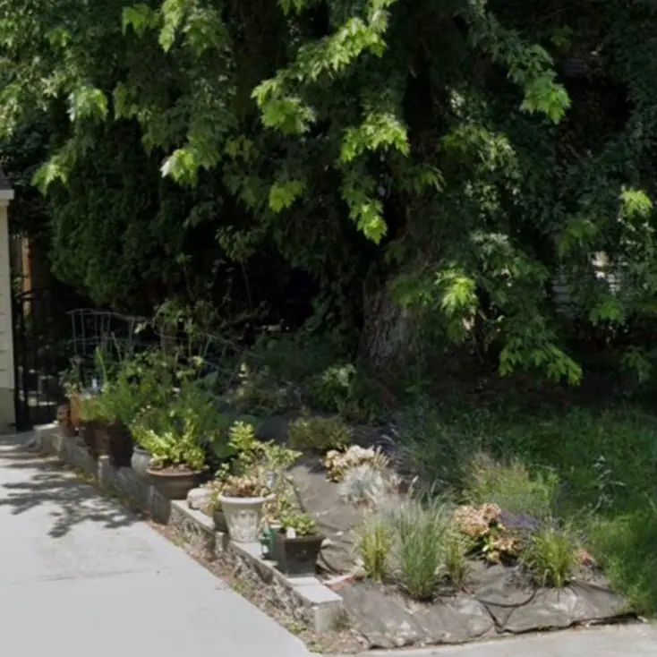 Flower bed with stone edging beside a sidewalk
